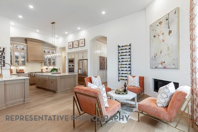 1708 Snowdrop Dr, Georgetown, TX 78628 - living room with arched walkways, a glass covered fireplace, light wood-style floors, and recessed lighting
