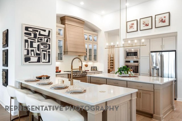 1708 Snowdrop Dr, Georgetown, TX 78628 - kitchen with a peninsula, a kitchen breakfast bar, wood finished floors, a kitchen island, and appliances with stainless steel finishes