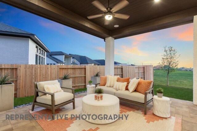 1708 Snowdrop Dr, Georgetown, TX 78628 - patio terrace at dusk featuring a fenced backyard, outdoor lounge area, and a ceiling fan