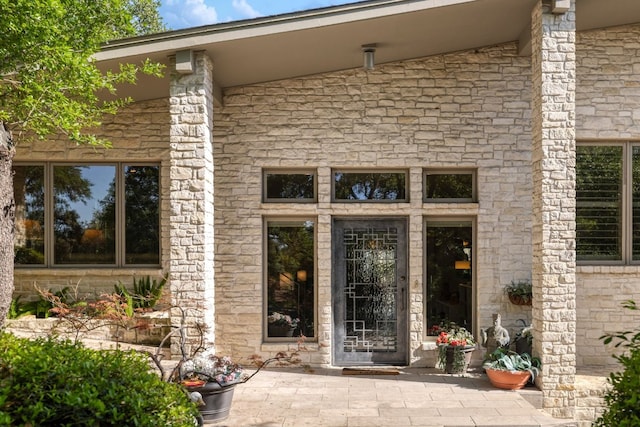 doorway to property with a patio area and stone siding