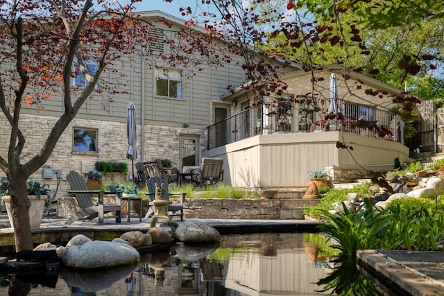 back of house featuring stone siding