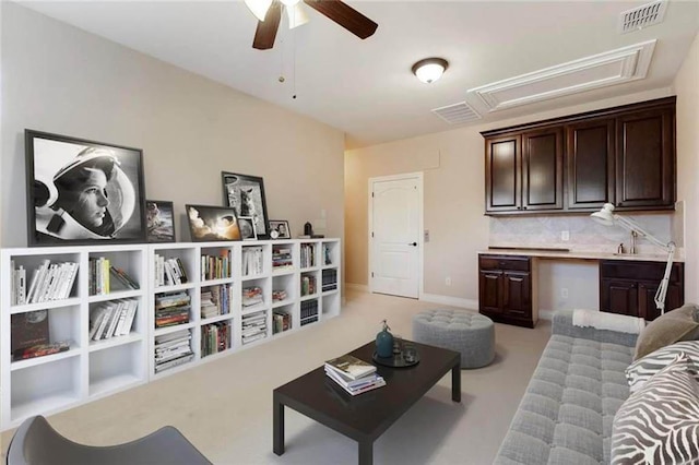 living room featuring visible vents, attic access, and a ceiling fan