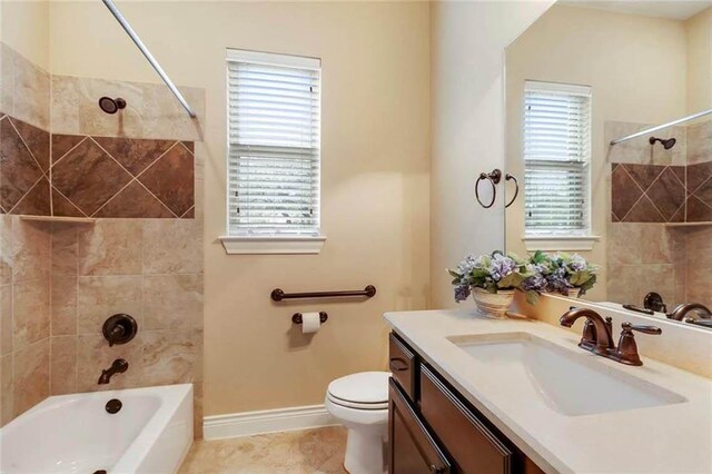 bathroom featuring vanity, baseboards, toilet, and tub / shower combination