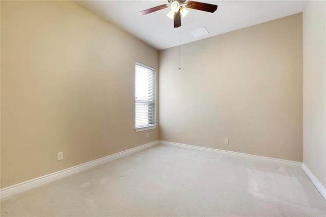 unfurnished room with a ceiling fan, baseboards, and light colored carpet