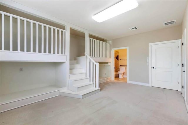 staircase featuring carpet floors, baseboards, and visible vents