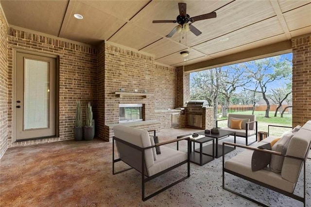 view of patio / terrace featuring area for grilling, an outdoor kitchen, a ceiling fan, and an outdoor living space with a fireplace