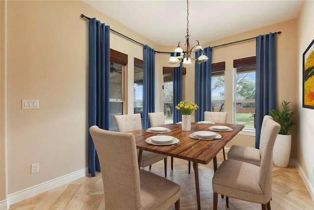 dining area featuring baseboards and a notable chandelier