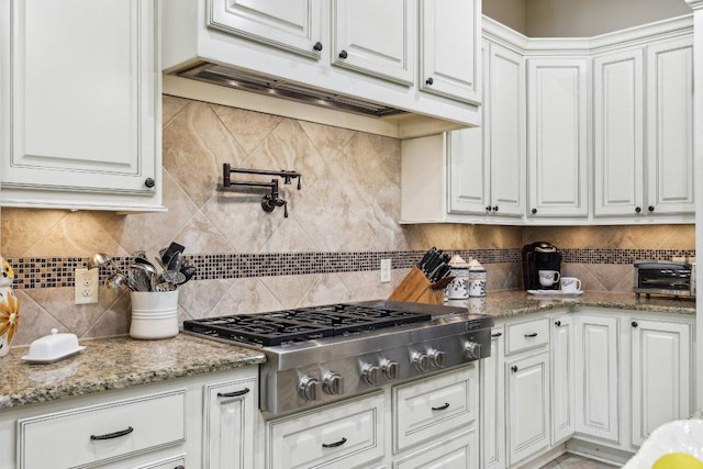 190 Estrella Xing, Georgetown, TX 78628 - kitchen featuring stainless steel gas stovetop, white cabinetry, tasteful backsplash, and light stone countertops