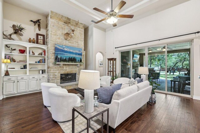 190 Estrella Xing, Georgetown, TX 78628 - living room featuring a towering ceiling, a fireplace, dark wood-style floors, ceiling fan, and a tray ceiling