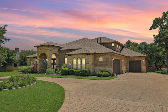 190 Estrella Xing, Georgetown, TX 78628 - french country home with driveway, an attached garage, brick siding, stone siding, and roof with shingles