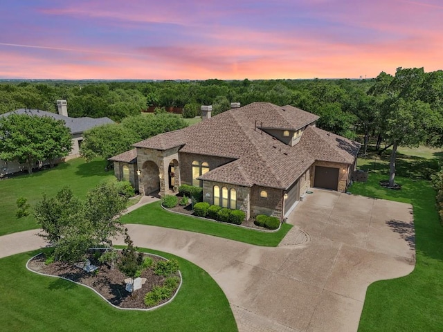 190 Estrella Xing, Georgetown, TX 78628 - mediterranean / spanish house with stone siding, curved driveway, a garage, and a front yard