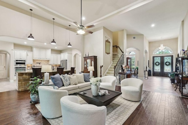 190 Estrella Xing, Georgetown, TX 78628 - living area with arched walkways, stairway, dark wood-type flooring, recessed lighting, and a high ceiling