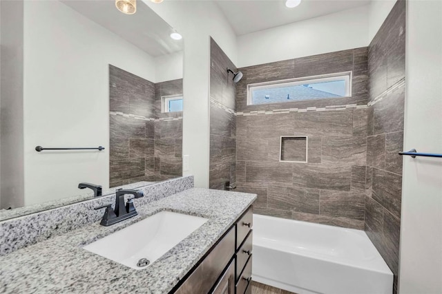bathroom featuring vanity, washtub / shower combination, and plenty of natural light