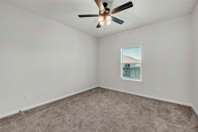 carpeted spare room with ceiling fan and baseboards