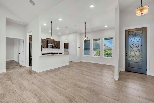 kitchen featuring dark brown cabinets, baseboards, visible vents, stainless steel microwave, and light countertops