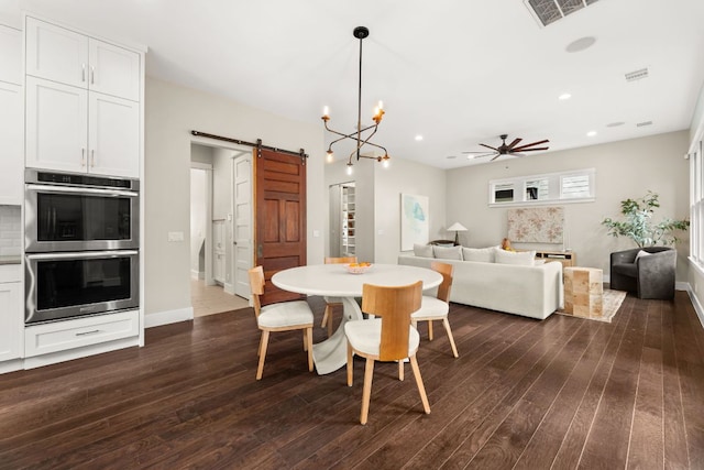 dining room featuring a barn door, visible vents, dark wood-style flooring, and ceiling fan with notable chandelier