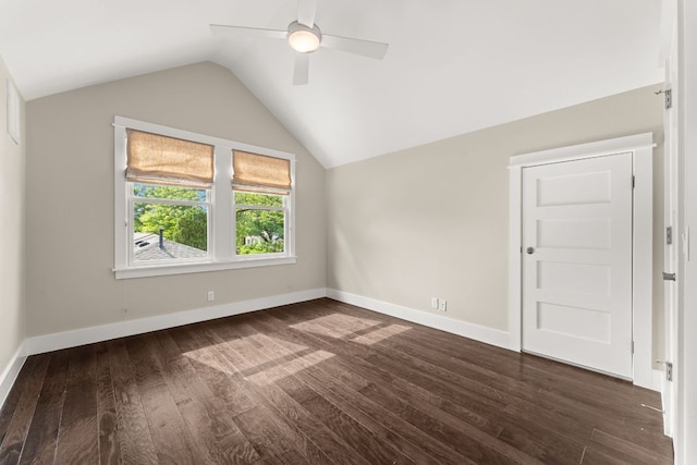 additional living space featuring vaulted ceiling, a ceiling fan, dark wood-type flooring, and baseboards