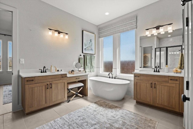 2108 Tobiano Trce, Georgetown, TX 78633 - bathroom with two vanities, a shower stall, tile patterned floors, and a freestanding tub
