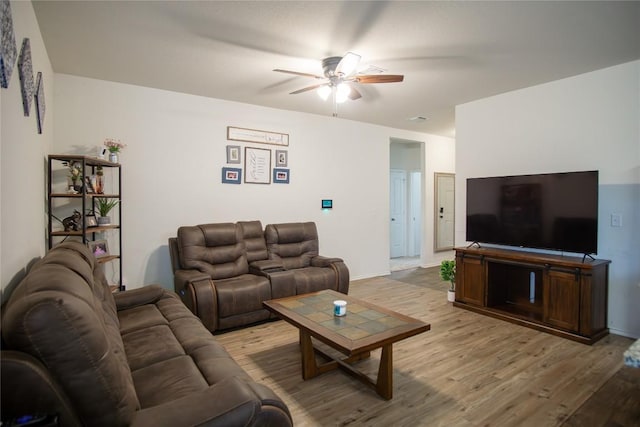 living area featuring visible vents, baseboards, light wood-style floors, and ceiling fan