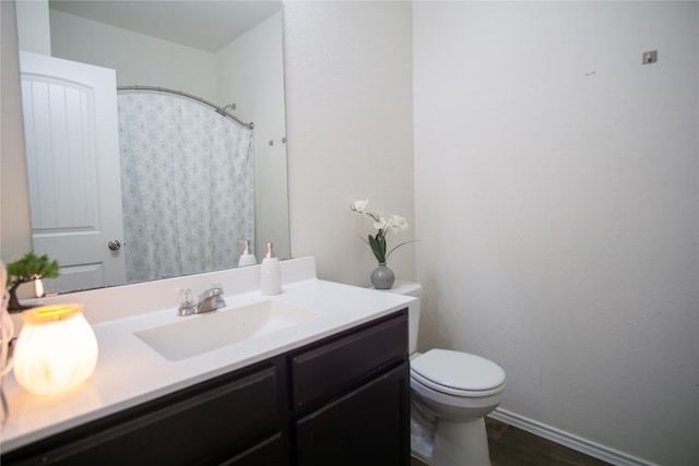 bathroom with baseboards, vanity, a shower with shower curtain, and toilet