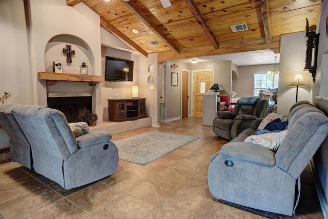 living room featuring lofted ceiling with beams, wooden ceiling, visible vents, and a fireplace with raised hearth