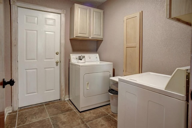 washroom featuring separate washer and dryer and cabinet space