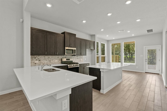 2705 Sage Ranch Dr Unit 30, Leander, TX 78641 - kitchen with a sink, appliances with stainless steel finishes, light wood finished floors, baseboards, and light countertops