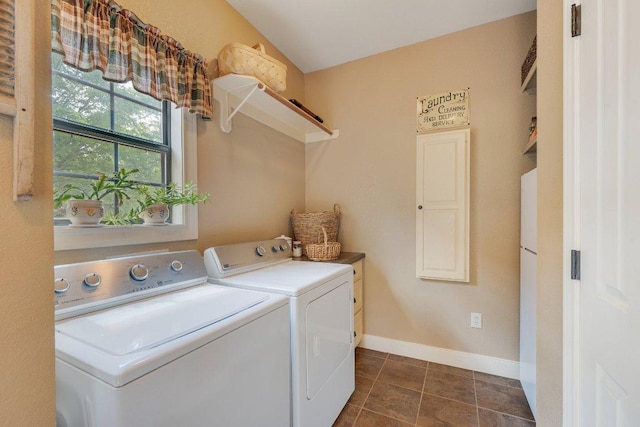 clothes washing area with separate washer and dryer, baseboards, and laundry area