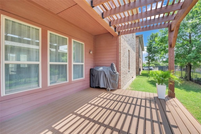 wooden terrace with a pergola, area for grilling, a lawn, and a fenced backyard