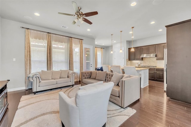living area with a ceiling fan, visible vents, dark wood-style floors, and recessed lighting