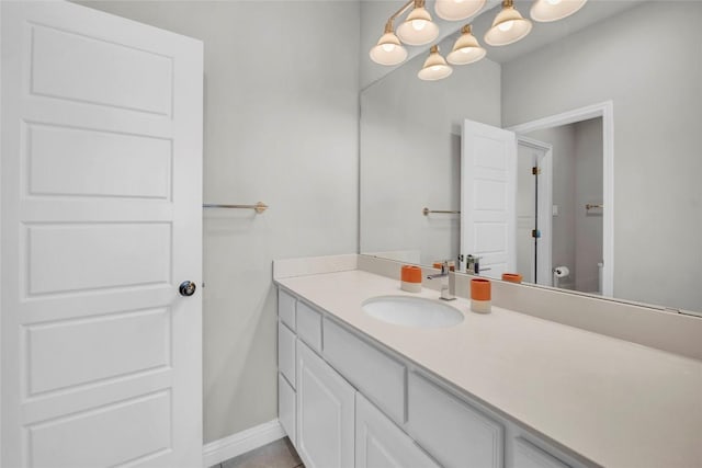 bathroom featuring vanity, a chandelier, and toilet
