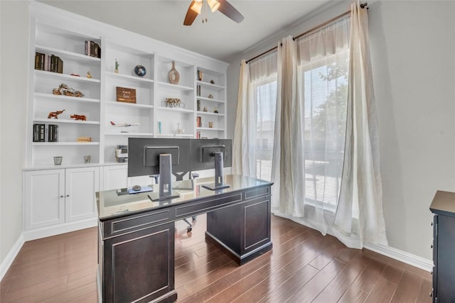 office featuring baseboards, a ceiling fan, and dark wood-style floors