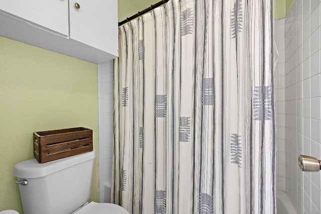 full bathroom with toilet and shower / bath combo with shower curtain