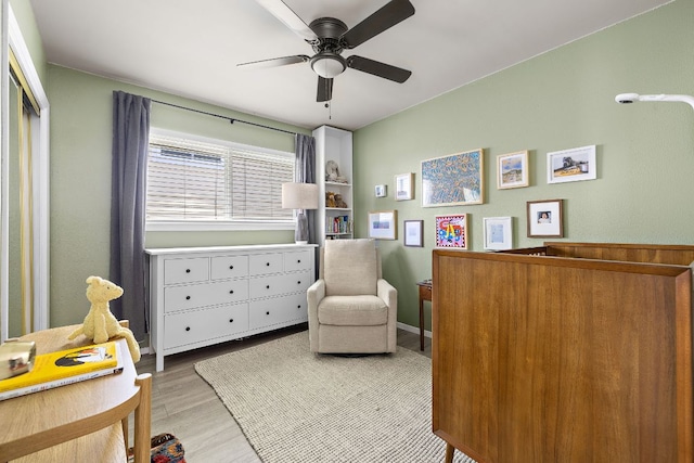 sitting room featuring baseboards, a ceiling fan, and wood finished floors