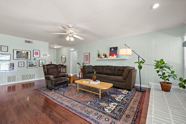 living room featuring wood finished floors, visible vents, a ceiling fan, and baseboards
