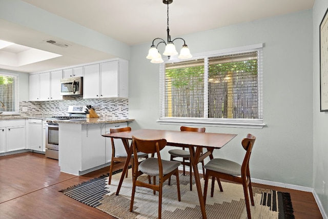 dining space featuring a notable chandelier, visible vents, baseboards, and dark wood-style flooring