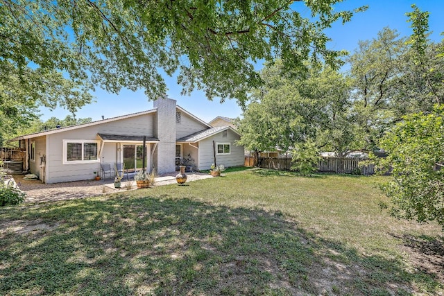 rear view of house with fence, a yard, cooling unit, and a patio