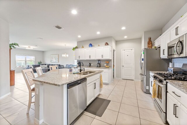 kitchen with appliances with stainless steel finishes, a breakfast bar, tasteful backsplash, and a sink