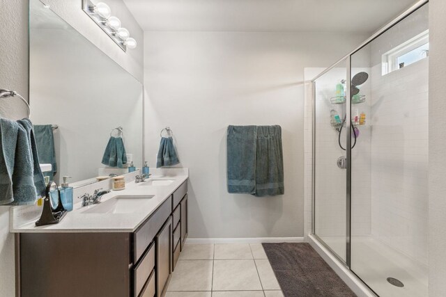 bathroom featuring double vanity, tile patterned flooring, a stall shower, and a sink