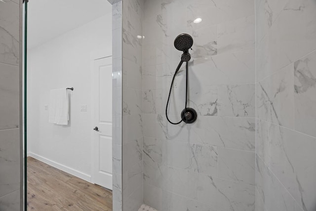 17701 Village Dr, Dripping Springs, TX 78620 - bathroom with tiled shower, wood finished floors, and baseboards
