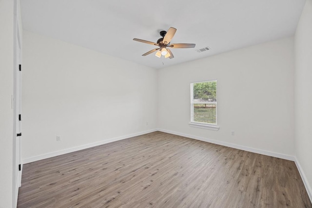 17701 Village Dr, Dripping Springs, TX 78620 - empty room with wood finished floors, ceiling fan, and baseboards