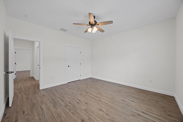 17701 Village Dr, Dripping Springs, TX 78620 - unfurnished bedroom with wood finished floors, baseboards, and ceiling fan