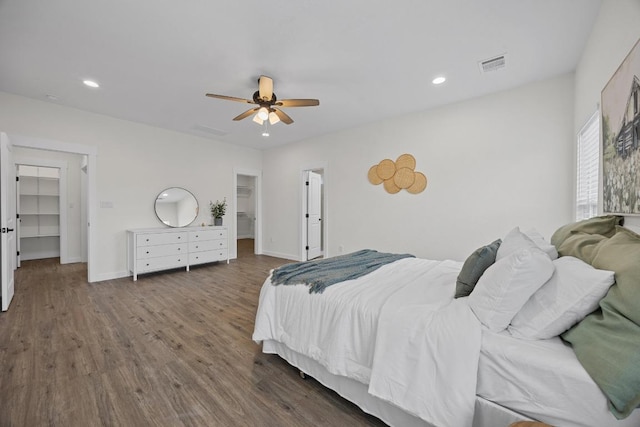 17701 Village Dr, Dripping Springs, TX 78620 - bedroom featuring a walk in closet, a closet, wood finished floors, recessed lighting, and baseboards