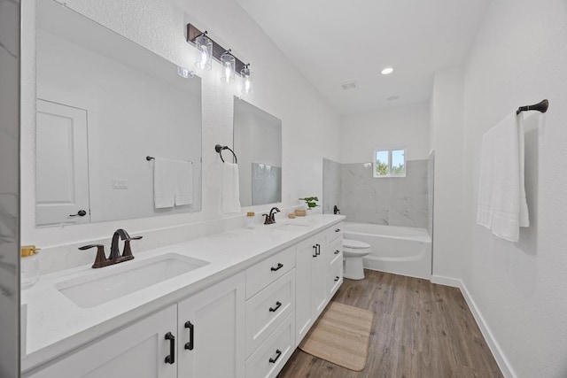 17701 Village Dr, Dripping Springs, TX 78620 - bathroom with double vanity, wood finished floors, toilet, and baseboards
