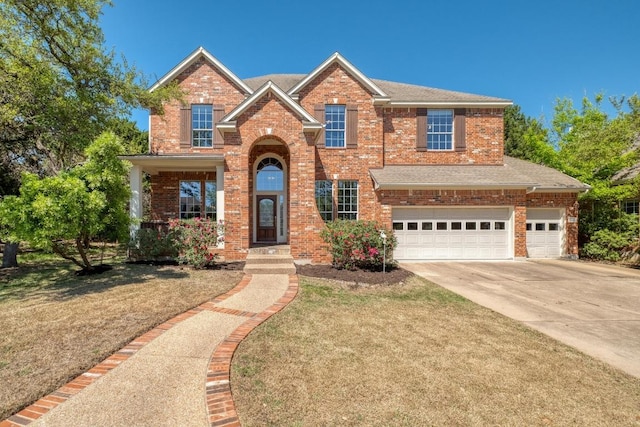traditional home with an attached garage, brick siding, a front yard, and concrete driveway