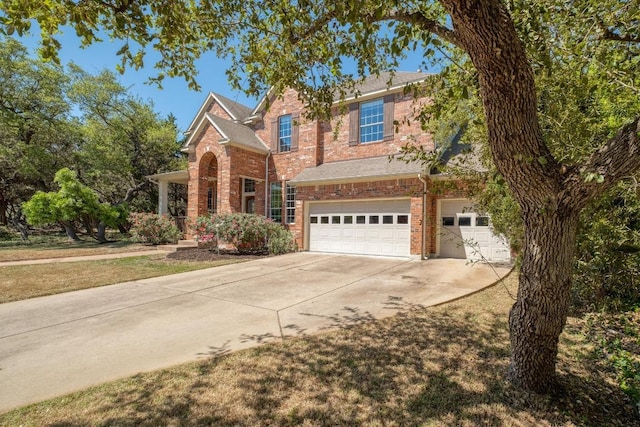 traditional-style home featuring an attached garage, driveway, and brick siding