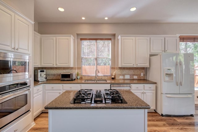 kitchen featuring a sink, recessed lighting, white cabinets, appliances with stainless steel finishes, and a kitchen island