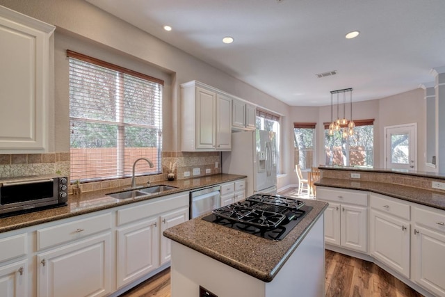 kitchen featuring white cabinets, a sink, visible vents, light wood-style floors, and appliances with stainless steel finishes