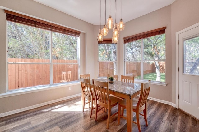dining room with baseboards, wood finished floors, and an inviting chandelier