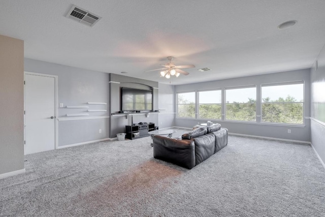 living room featuring baseboards, a ceiling fan, visible vents, and carpet